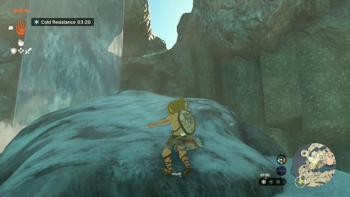 Image taken from The Legend of Zelda: Tears of the Kingdom showing Link standing on a snowy, large rock with a waterfall in the background.