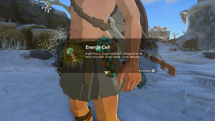 Image taken from The Legend of Zelda: Tears of the Kingdom showing an in-game description for the Energy Cell item. In the background a snowy, rocky region can be seen.
