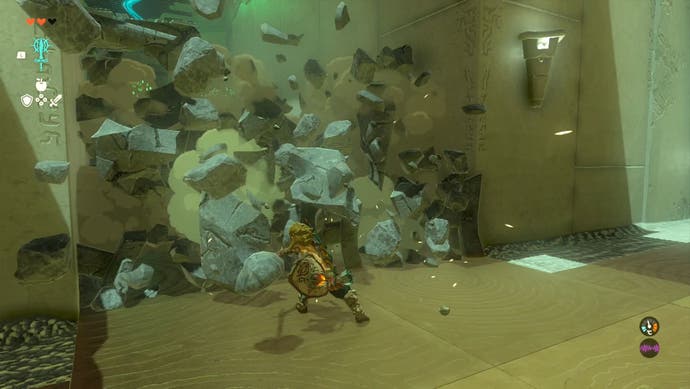 Link destroying and collapsing a stone wall at the In-Isa Shrine in The Legend of Zelda: Tears of the Kingdom.