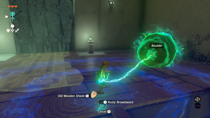 Link using the Fuse ability on a boulder in the In-Isa Shrine in The Legend of Zelda: Tears of the Kingdom.
